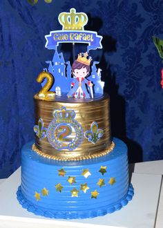 a blue and gold birthday cake with a princess on top