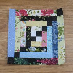 a close up of a piece of cloth on a wooden floor with flowers and leaves