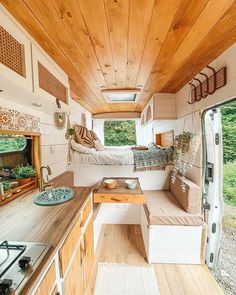 an interior view of a tiny home with wood paneling and white walls, wooden flooring