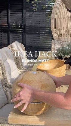 a woman sitting at a table with a wooden bowl on it