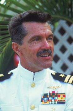 a man in uniform is smiling for the camera while wearing a mustache and moustache