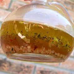 a glass jar filled with liquid sitting on top of a brick wall