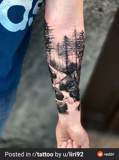 a man with a forest tattoo on his arm