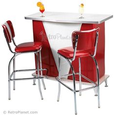 two red chairs sitting next to a white counter with an orange drink on top and another chair at the back