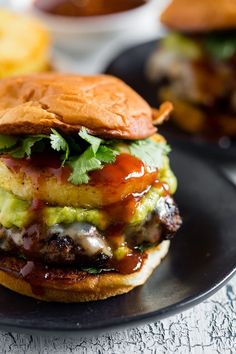 a burger with meat, lettuce and sauce on it sitting on a plate