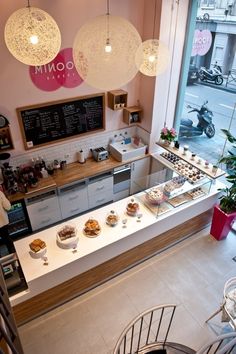 an overhead view of a bakery with donuts on the counter and hanging lights above