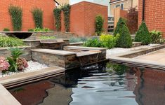 an outdoor pond surrounded by stone steps and water features in the middle of a courtyard