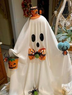 a white ghost with two pumpkins on it's legs and a cup in its mouth