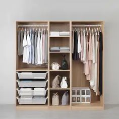 an open closet with clothes and other items on the shelves in front of white walls