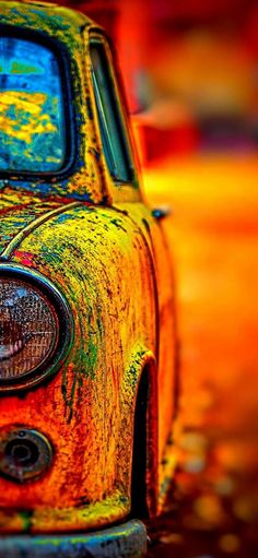 an old rusty car is parked on the street