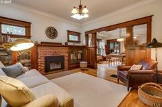 a living room filled with furniture and a fire place under a clock mounted on the wall