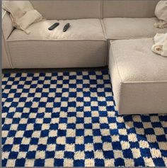 a blue and white checkered rug with a couch in the middle on top of it