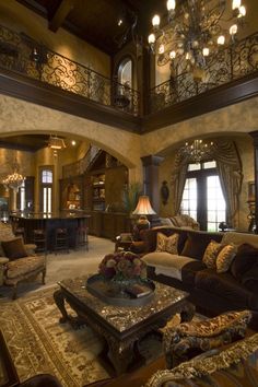 a living room filled with furniture and a chandelier hanging from the ceiling above