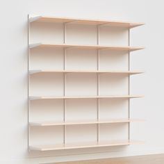 a white book shelf on the wall in an empty room