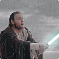 a man holding a light saber in the rain