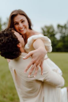 a woman in a white dress is hugging a man