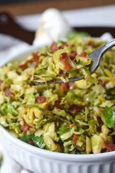 a close up of a bowl of food with broccoli and bacon in it