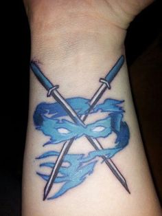 a tattoo with two swords on the wrist