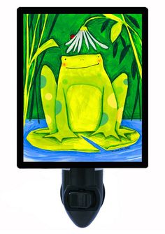 a green frog sitting on top of a computer monitor next to a wall mounted light