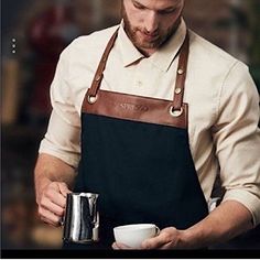 Elevate Your Barista Game With This Modern And Stylish Chef Apron. Designed With Beige Fabric And Brown Faux Leather, This Apron Is Perfect For Both Men And Women. The Apron Features A Solid Pattern And Is Made From Upcycled Nespresso Materials, Making It A Sustainable Choice For Any Environmentally-Conscious Barista. In Addition To Its Trendy Design, This Apron Is Also Functional. It Is Machine Washable And Iron Safe, Making Cleanup A Breeze. Whether You're A Professional Barista Or A Home Coff Nespresso Kitchen, Barista Uniform, Barista Style, Cafe Uniform, Waiter Uniform, Barista Apron, Blue Cafe, Brown Leather Top, Restaurant Uniforms