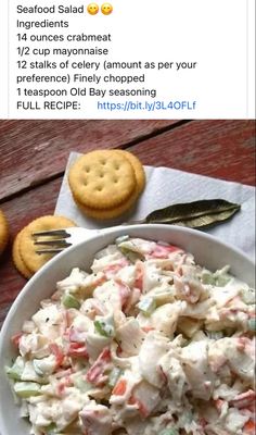 a white bowl filled with salad next to crackers