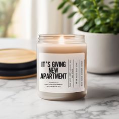 a candle sitting on top of a table next to a potted plant