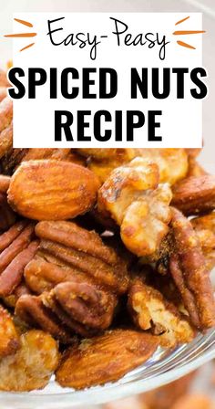 a glass bowl filled with spiced nuts on top of a white tablecloth and text overlay reads easy - peasy spiced nuts recipe