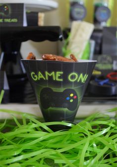 a game on bowl sitting on top of green grass next to a video game controller