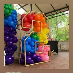 there are many balloons in the shape of a house that is made out of different colors