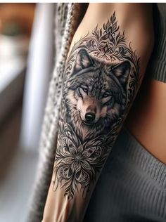 a woman's arm with a wolf tattoo on it