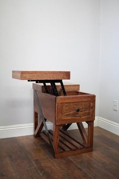 a wooden table with a drawer on top and two knives in the bottom section, against a white wall