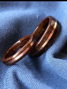 two wooden rings sitting on top of a blue cloth