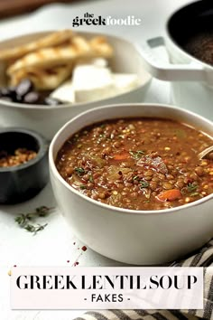 there is a bowl of soup on the table next to other bowls and spoons