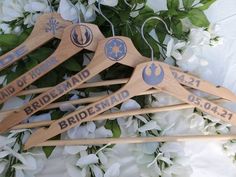 wooden wedding hangers with star wars emblems on them and flowers in the background