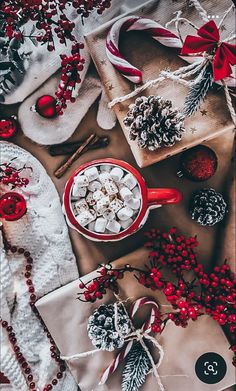 a table topped with lots of christmas decorations next to wrapping paper and candy canes