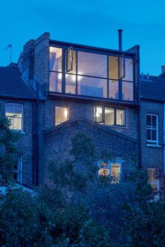 a tall brick building with lots of windows on it's sides at night time