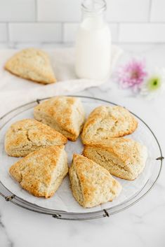 biscuits on a plate next to a bottle of milk