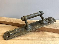 an old metal object sitting on top of a wooden table