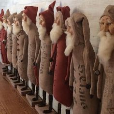 a row of wooden santas lined up against a wall