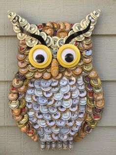 an owl made out of bottle caps on the side of a building