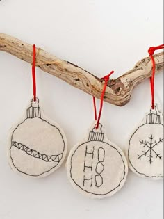 three ornaments hanging from a tree branch