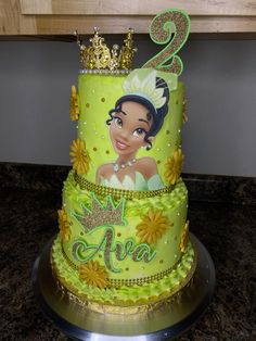 a two tiered cake with a princess and the frog on it's side