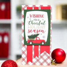 a christmas card sitting on top of a table next to a red ornament