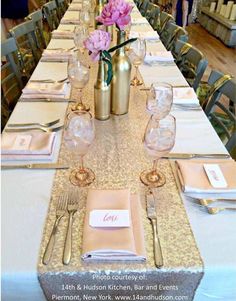 the table is set with silverware and pink flowers