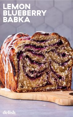 a loaf of lemon blueberry bake sitting on top of a wooden cutting board