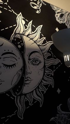 an artistic wallpaper with sun and moon designs on it's face, next to a lamp