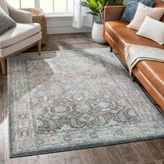 a living room area with couches, chairs and rugs