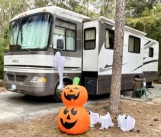 two pumpkins sitting in front of a motor home