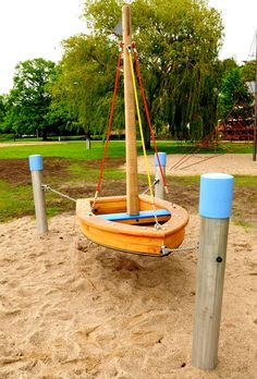 a small sailboat sitting on top of a sandy beach next to a wooden pole