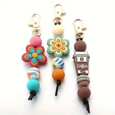 four different types of keychains with flowers and coffee beans on them, all in various colors